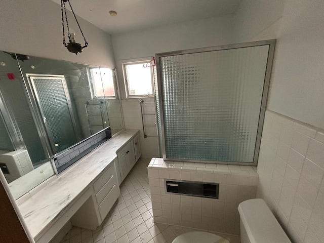 bathroom with tile walls, vanity, tile patterned flooring, and an enclosed shower