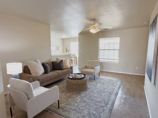 living room with wood-type flooring and ceiling fan