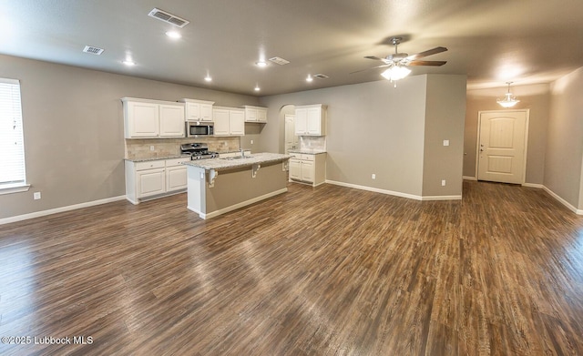 5234 Jarvis St, Lubbock, TX 79416 - kitchen with stainless steel appliances, dark wood finished floors, a ceiling fan, white cabinetry, and backsplash
