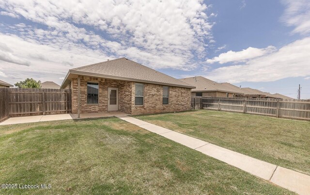 5234 Jarvis St, Lubbock, TX 79416 - back of house featuring brick siding, a fenced backyard, a patio area, and roof with shingles