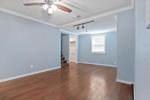 empty room with a textured ceiling, track lighting, ornamental molding, ceiling fan, and hardwood / wood-style floors