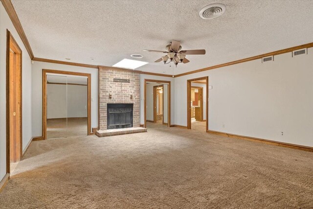 unfurnished living room featuring crown molding, ceiling fan, light colored carpet, and a brick fireplace