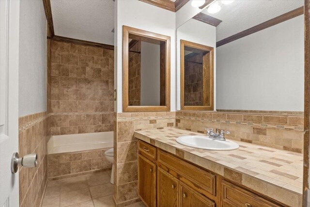 full bathroom with tile patterned flooring, vanity, toilet, crown molding, and a textured ceiling