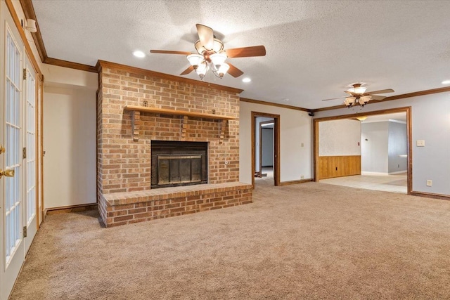 unfurnished living room featuring a fireplace, ornamental molding, a textured ceiling, and carpet flooring