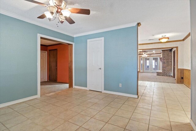 spare room with crown molding, light tile patterned floors, and a textured ceiling