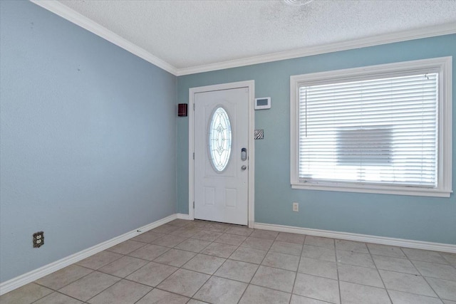 tiled foyer with ornamental molding and a textured ceiling