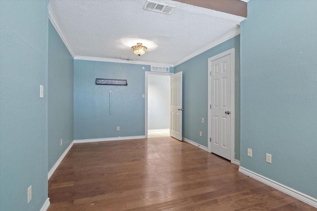 unfurnished room featuring wood-type flooring, ornamental molding, and a textured ceiling