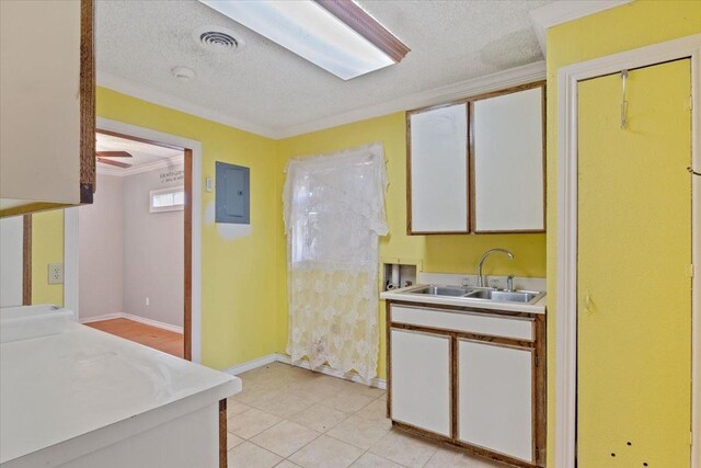 kitchen with white cabinetry, light tile patterned floors, and crown molding