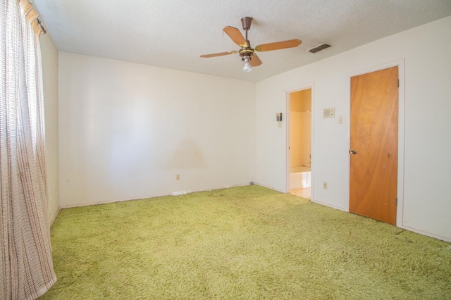 carpeted spare room with ceiling fan and a textured ceiling