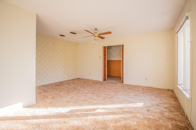 carpeted spare room featuring ceiling fan