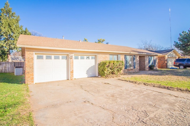 single story home with a garage and a front lawn