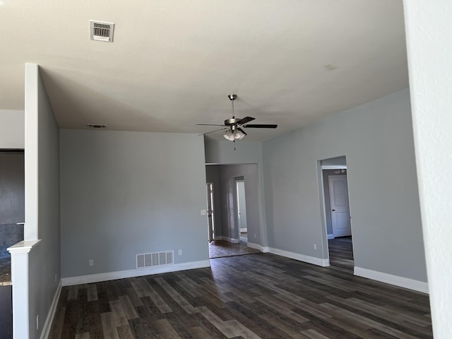 spare room with dark wood-style floors, baseboards, visible vents, and a ceiling fan