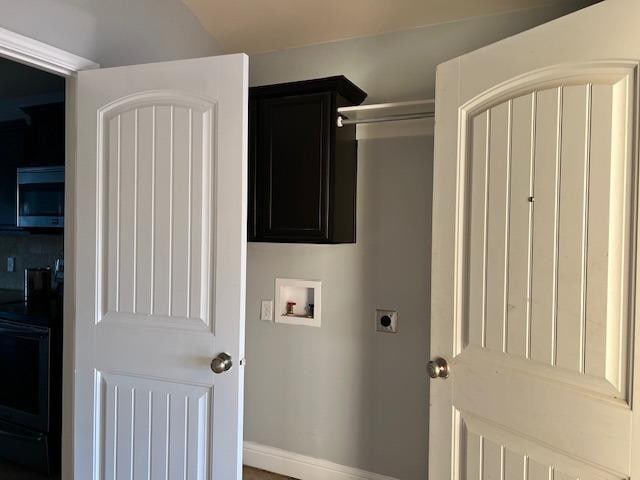 clothes washing area featuring cabinets, electric dryer hookup, and washer hookup