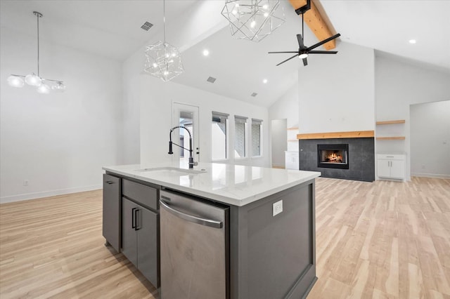 kitchen with a kitchen island with sink, sink, beam ceiling, and stainless steel dishwasher