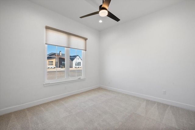 empty room featuring ceiling fan and carpet