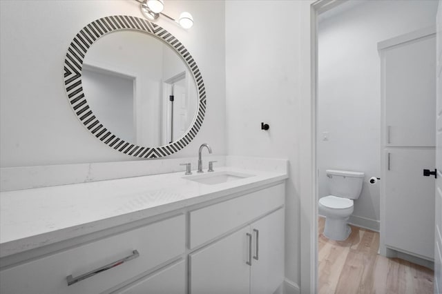 bathroom with wood-type flooring, toilet, and vanity