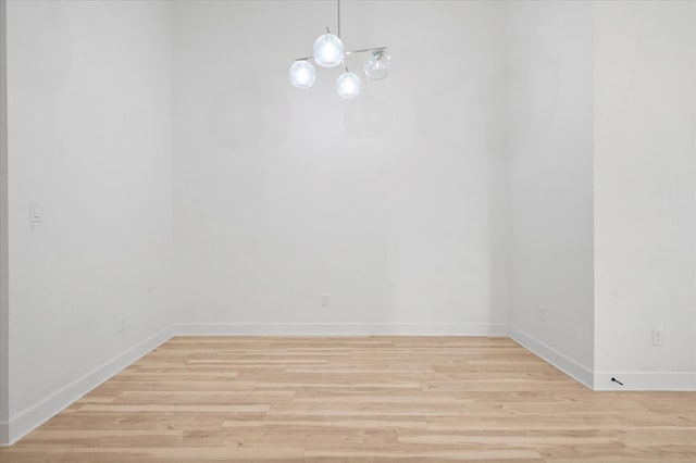 unfurnished dining area with light hardwood / wood-style floors and a chandelier