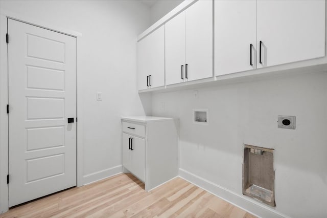 clothes washing area featuring cabinets, hookup for an electric dryer, hookup for a washing machine, and light hardwood / wood-style flooring