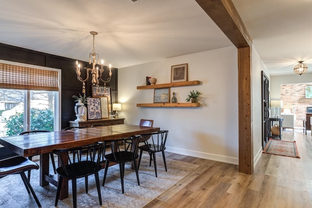 dining area featuring wood-type flooring and a chandelier