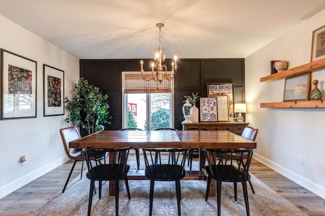 dining room with hardwood / wood-style floors and a chandelier