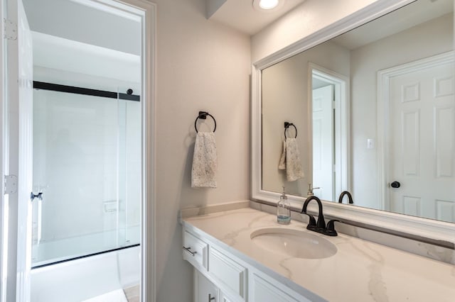 bathroom with vanity and combined bath / shower with glass door