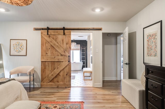 bedroom featuring a barn door and light hardwood / wood-style floors