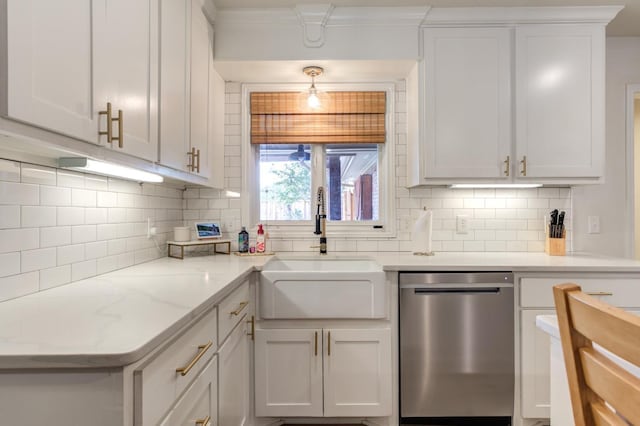 kitchen with pendant lighting, sink, light stone countertops, white cabinets, and stainless steel dishwasher