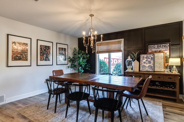 dining area with an inviting chandelier and hardwood / wood-style flooring