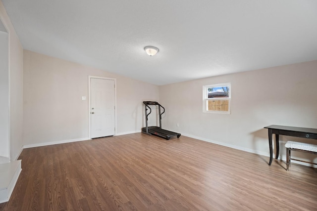 workout area with hardwood / wood-style floors and a textured ceiling