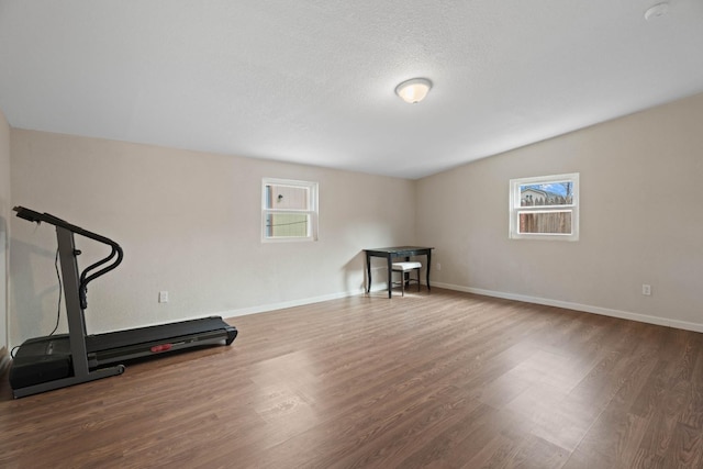 workout area featuring dark hardwood / wood-style flooring and a textured ceiling