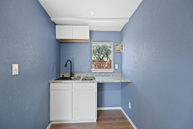 kitchen with dark hardwood / wood-style flooring, sink, and white cabinets