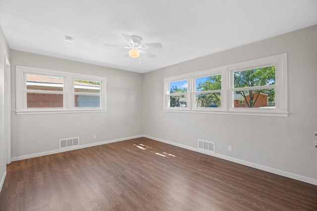 unfurnished room with a healthy amount of sunlight and dark hardwood / wood-style flooring