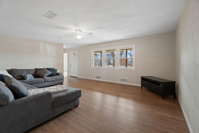 living room with dark wood-type flooring and ceiling fan