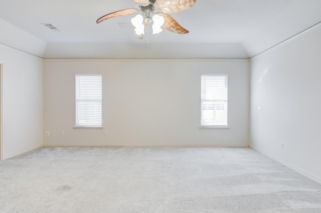 empty room with ceiling fan, lofted ceiling, light carpet, and a wealth of natural light