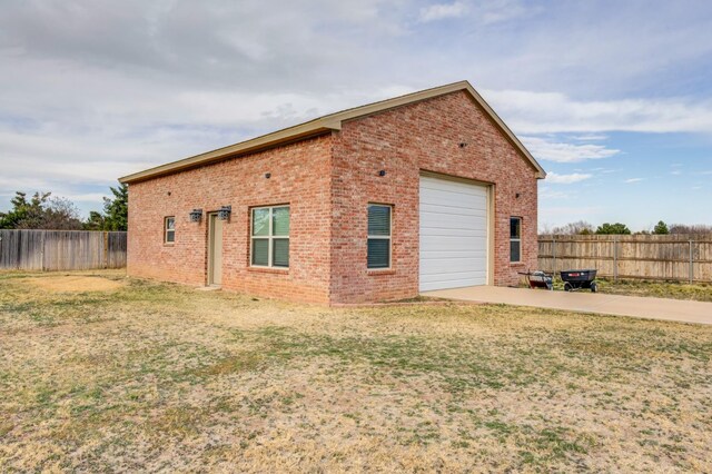 view of side of property featuring a garage and a lawn