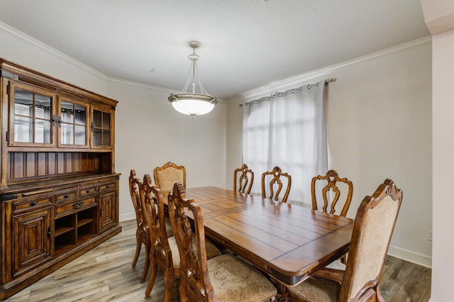 dining room with ornamental molding and light wood-type flooring