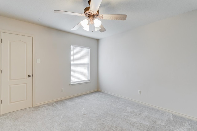 spare room featuring light colored carpet and ceiling fan