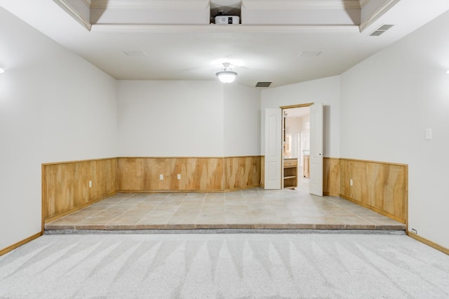 carpeted spare room featuring ornamental molding and wooden walls