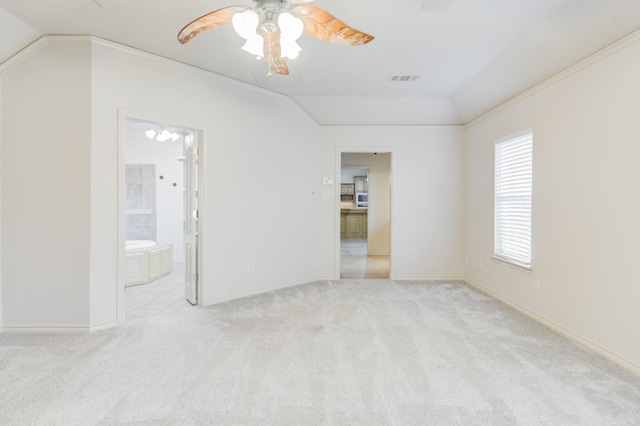 carpeted empty room featuring vaulted ceiling, ornamental molding, and ceiling fan