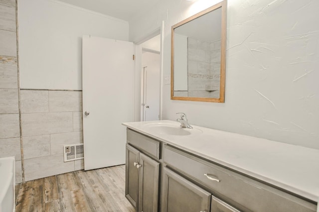 bathroom featuring vanity, hardwood / wood-style floors, and tile walls