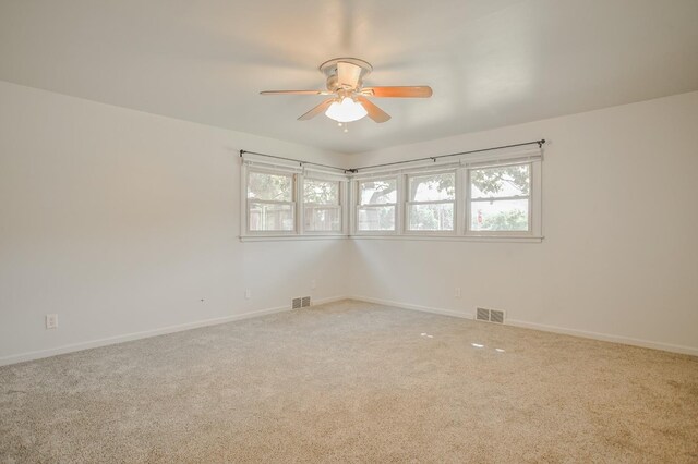 carpeted spare room featuring ceiling fan