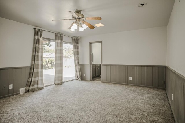 unfurnished room featuring ceiling fan and carpet