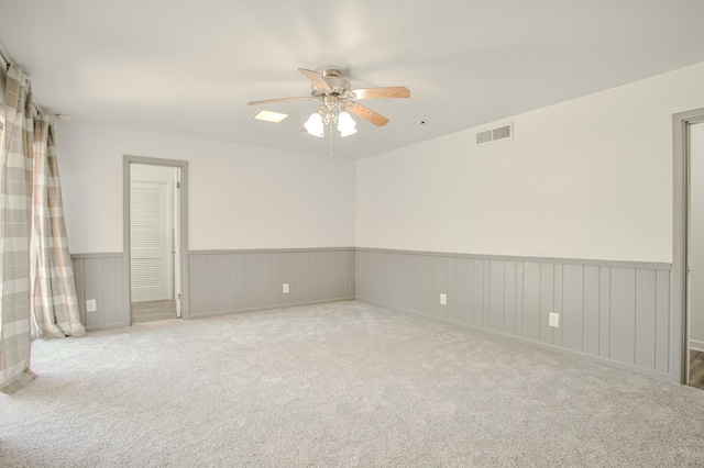 carpeted spare room with ceiling fan