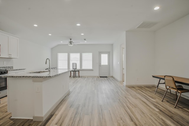 kitchen with light wood finished floors, a ceiling fan, a sink, and visible vents