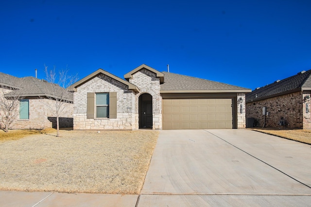 view of front of home featuring brick siding, driveway, stone siding, cooling unit, and an attached garage