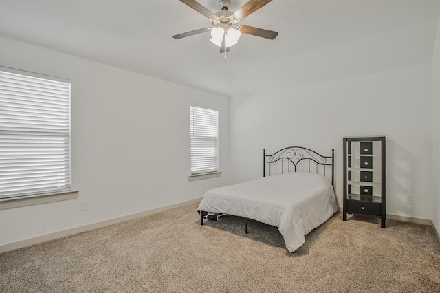 bedroom with a ceiling fan, light carpet, and baseboards