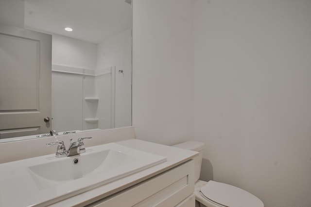 bathroom featuring vanity, toilet, and recessed lighting