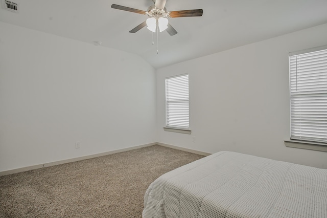 carpeted bedroom featuring baseboards, visible vents, a ceiling fan, and lofted ceiling