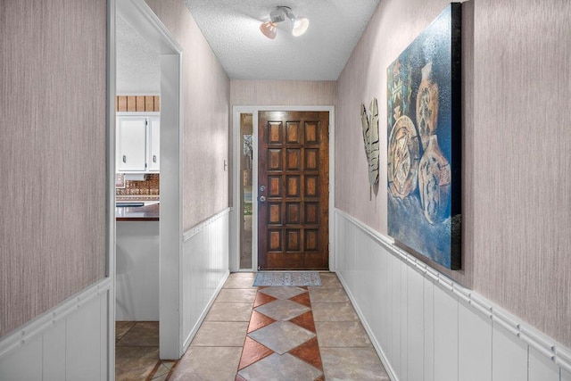 4405 56th St, Lubbock, TX 79414 - entrance foyer featuring a wainscoted wall, a textured ceiling, and light tile patterned flooring