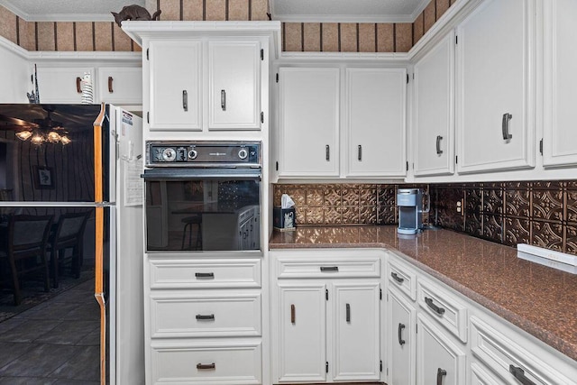 4405 56th St, Lubbock, TX 79414 - kitchen with black oven, white cabinetry, tasteful backsplash, and dark stone counters